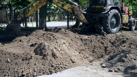 Tractor pits the ground. Backhoe piles u... | Stock Video | Pond5