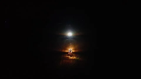 Tractor planting crops at night with powerful headlights in farmland Formosa Stock Footage 332659907
