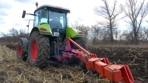 Tractor ploughing ground of agro field at spring Stock Footage 75442680