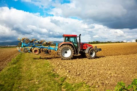 Tractor with plow on field Stock Photos