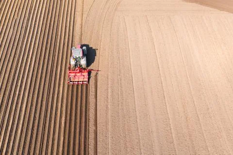 Tractor on a plowed field, top view. Agricultural field for planting vegetables. Stock Photos