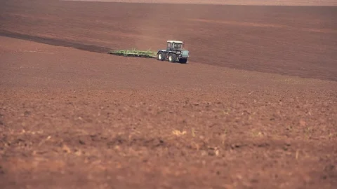 A tractor plowing and sowing in the field. Panoramic format Stock Footage 149100694