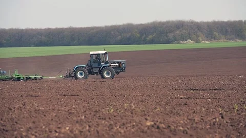 A tractor plowing and sowing in the field. Panoramic format Stock Footage 149100820