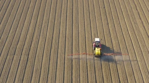 Tractor plowing and spraying on field. Vídeos de archivo 118798063