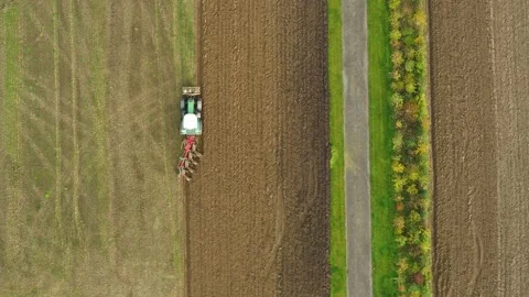 Tractor plowing a big field in the spring time, drone stock footage by DroneR Stock Footage 138694731