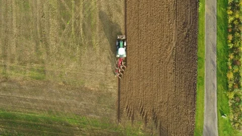 Tractor plowing a big field in the spring time, drone stock footage by DroneR Stock Footage 138694944