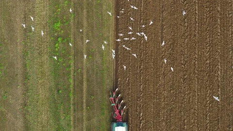Tractor plowing a big field in the spring time, drone stock footage by DroneR Stock Footage 138695277