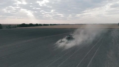 Tractor Plowing Field In A Cloud Of Dirt Slow Motion Aerial Long Shot Stock Footage 316712755