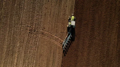 Tractor plowing field, drone view. Cultivated land and soil tillage. Stockbeeldmateriaal 191836012