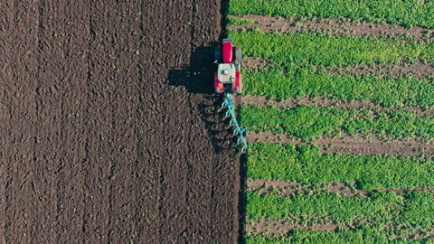 Tractor plowing a field with a plow. Modern efficient agriculture aerial view Stock Footage 290783975