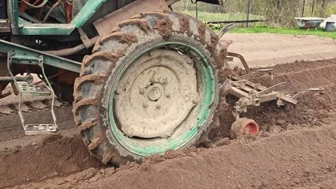 Tractor plowing field to prepare soil for planting agricultural crops. Close-up Stock Footage 169302180