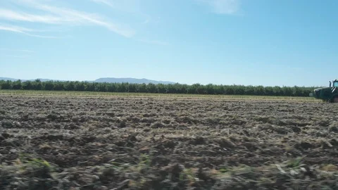 Tractor Plowing Field With Rolling Mountain View Stock Footage 89783437