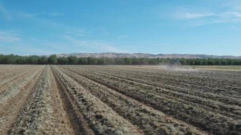 Tractor Plowing Field With Rolling Mountain View Stock Footage 89783469