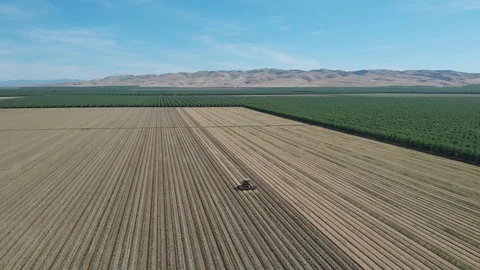 Tractor Plowing Field With Rolling Mountain View Stock Footage 89783966