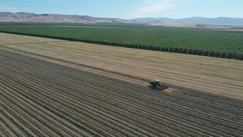 Tractor Plowing Field With Rolling Mountain View Stock Footage 89784101