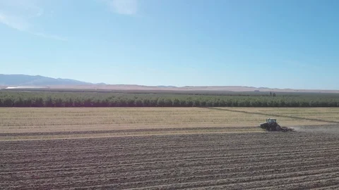 Tractor Plowing Field With Rolling Mountain View Stock Footage 89784170