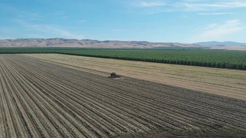 Tractor Plowing Field With Rolling Mountain View Stock Footage 89784406