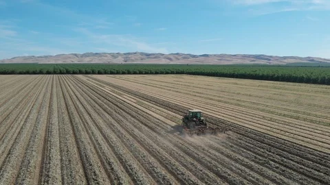 Tractor Plowing Field With Rolling Mountain View Stock Footage 89816877