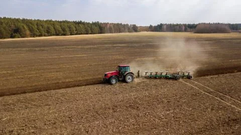 Tractor plowing field side view Stock Photos