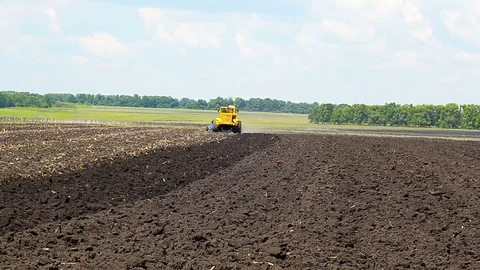 Tractor plowing field in spring ground Stock Footage