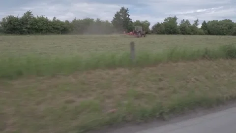 A Tractor Plowing Field in Summer Stock Footage 325351333