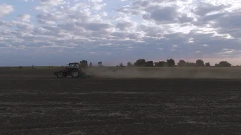 Tractor Plowing Field at Sunrise With Dramatic Clouds In The Background Stock Footage 316713303