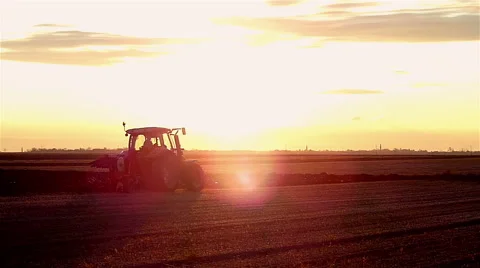 Tractor plowing field in sunset Stock Footage 48846325