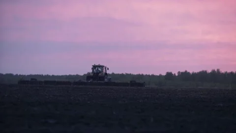 Tractor plowing a field at sunset Stock Footage 195094833