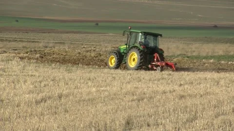 With tractor plowing fields Stock Footage