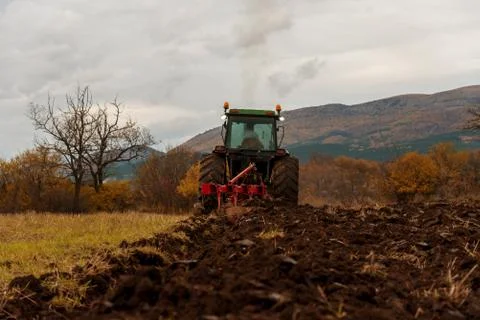 Tractor plowing fields. Stock Photos