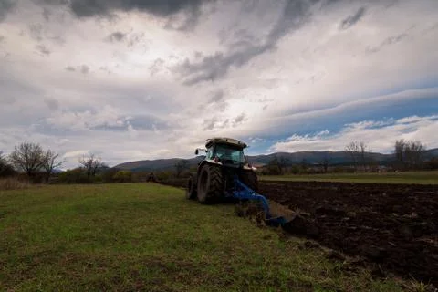 Tractor plowing fields Stock Photos