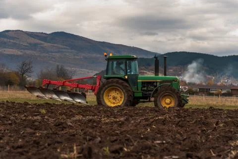 Tractor plowing fields Stock Photos