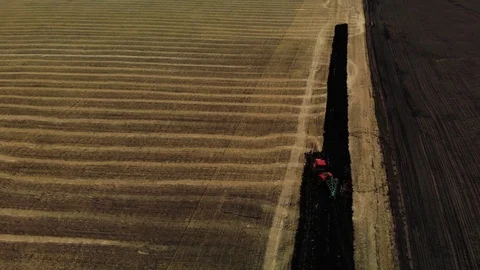 Tractor plowing fields, preparing land for sowing. Red tractor. Aerial view Stock Footage 114047006