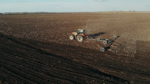 Tractor plowing fields, preparing land for sowing. Aerial view. Tractor plows a Stock Footage 128380308