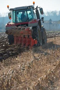 Tractor plowing fields, preparing land for sowing Stock Photos