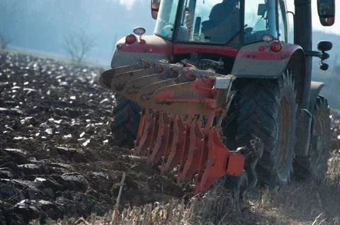 Tractor plowing fields, preparing land for sowing Stock Photos