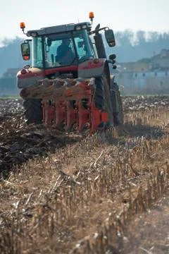 Tractor plowing fields, preparing land for sowing Stock Photos
