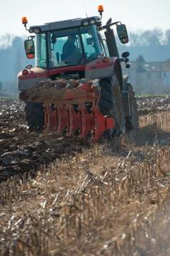 Tractor plowing fields, preparing land for sowing Stock Photos