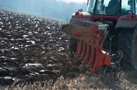 Tractor plowing fields, preparing land for sowing Stock Photos
