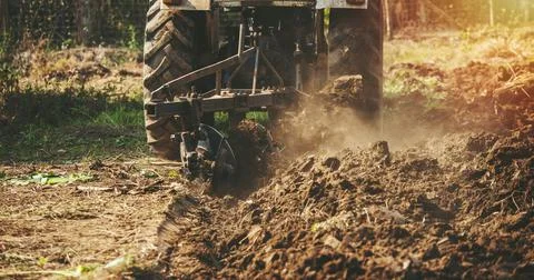 Tractor plowing fields preparing land for sowing Stock Photos