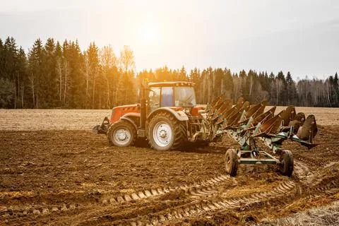 Tractor plowing fields - preparing land for sowing Stock Photos