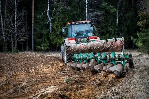 Tractor plowing fields - preparing land for sowing Stock Photos