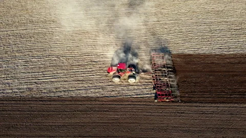 Tractor plowing ground preparing soil for palnting seeds. Agriculture farm Stock-Footage 196727452