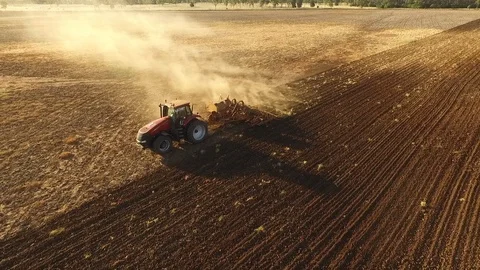 Tractor plowing in late afternoon in Queensland, Australia, drone reveal shot Stock Footage