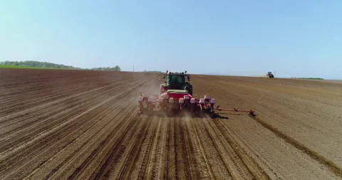 Tractor plowing a rural field under clear blue sky Video stock 336471122