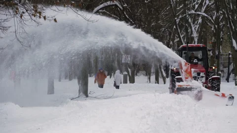A tractor is plowing snow in a park Vidéo 326351333