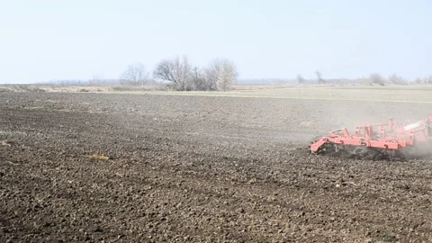 Tractor plowing the soil in spring closing the moisture, preparing the land for Stock Footage 172347661