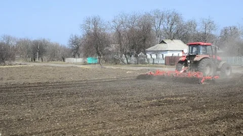 Tractor plowing the soil in spring closing the moisture, preparing the land for Stock Footage 172347684