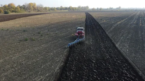 Tractor plows agricultural field. Processing the field with a tractor. Stock Footage 263985297