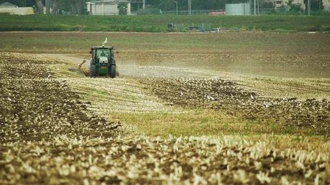 Tractor plows a corn field with a disk plow in southern Israel. Long Shot Stock Footage 93622147